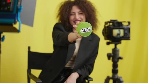 Woman Holds Aloe Vera Cream on Yellow Background