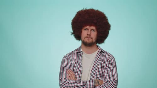Serious Man with Afro Stares with Arms Crossed
