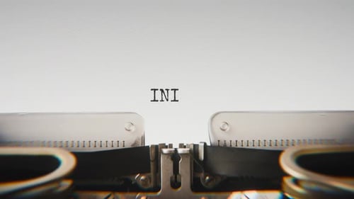 Old mechanical typewriter typing Initiative in a close-up view.