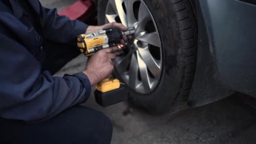 Mechanic Removing Tire with Power Tool Close Up