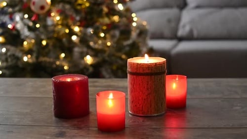 Christmas Candles Glowing with Decorated Tree in Background