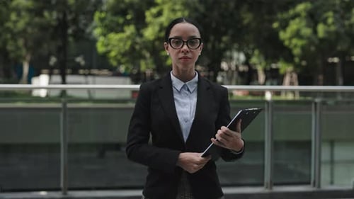 Business Woman in Urban Environment Holding Folder