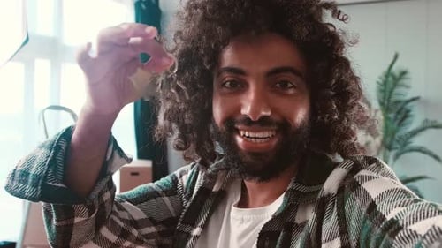 Young Adult Smiling with Keys to New Home