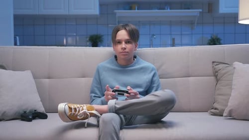 Teen Relaxing on Couch While Playing Video Games