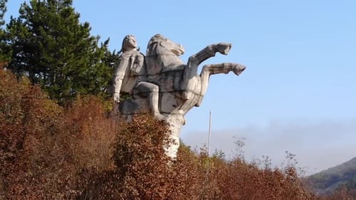 Statue de cavalier à cheval devant un feuillage coloré en automne à Targovishte, en Bulgarie. - Aerial Arc Sho