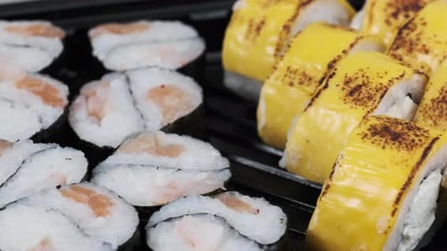 Sushi Rolls Rotating in Plastic Box