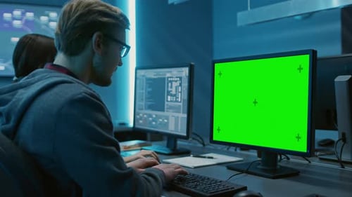 Smart Male IT Programer Working on Desktop Green Mock-up Screen Computer. Software Development / Co