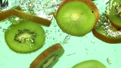 Vibrant Kiwi Slices Falling into Water
