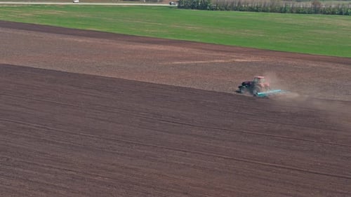 Red Tractor In The Field On A Spring Day