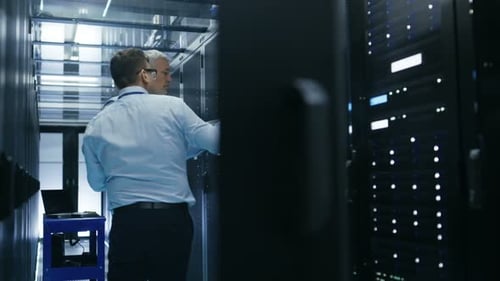 Zwei Servertechniker installieren Hardware im Server-Rack. Sie arbeiten in einem großen modernen Rechenzentrum.