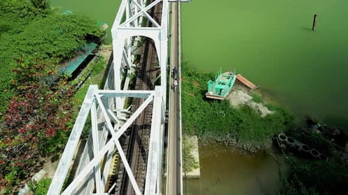 Aerial Shot to Biker Riding on Motorcycle on an Iron Bridge Through Forest to Road