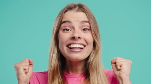 Excited Woman Cheering with Fists Pumped in Studio