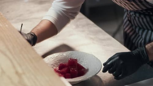 Young Chef Plating Marinated Tuna at Restaurant Kitchen