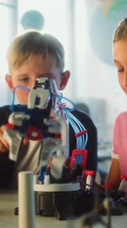 Elementary School Students Studying Model of Innovative Robotic Arm in Modern Classroom