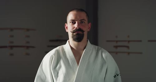 Cinematic shot of young male budokai fighter is smiling in camera after practicing Aikido in Japan