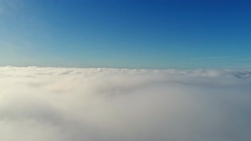 Drone view from above from the thick white clouds at sunrise. Amazing nature landscape, with white f