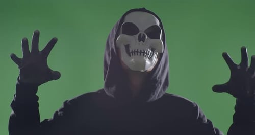 Close Up Of Crazy Man In The Hooded Sweatshirt Wearing Halloween Mask Angry In Green Screen Studio