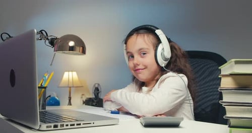 Caucasian Girl Child Studying on Laptop Studying at Home and Smiling at Camera