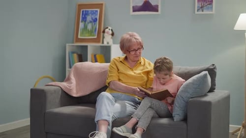 Grandmother Reading Book to Child on Couch