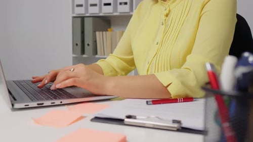 Woman hands typing down or taking on a laptop in office.