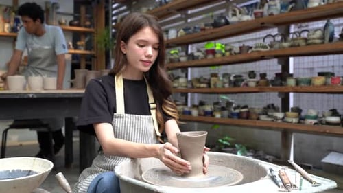 People Creating Pottery in Studio. Female artisan creating handmade ceramics in pottery workshop