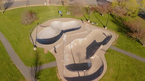 Skaters In Motion At Dartmouth Skatepark Viewed From Above On A Warm Sunny Day