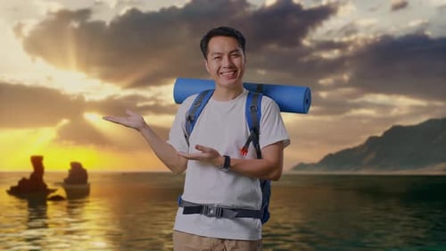 Asian Male Hiker Smiling And Pointing To Side on Beach