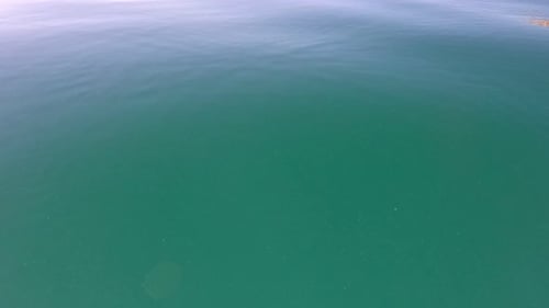 Meeresoberfläche, niedriger Winkel, Blick über klares, azurblaues Meerwasser, Sonnenblendung, abstrakter nautischer Sommerozean