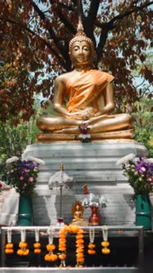 Golden Buddha Statue Sitting in Meditation Pose at an Outdoor Temple Altar