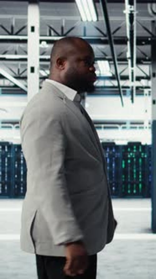 Vertical Video System Administrator Walking in Data Center with Rigs Doing Backups