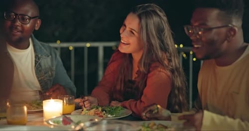Friends Enjoying Dinner and Conversation Outdoors at Night