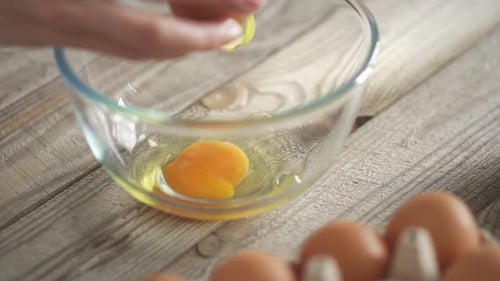 Woman Chef's Hands Break A Chicken Egg To Make Waffle Dough. Breaking The Egg Into A Bowl