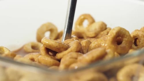 Golden Brown Cereal with Milk Being Stirred