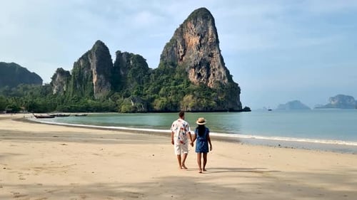 Couple Walks Hand in Hand Along Stunning Railay Beach in Krabi Thailand