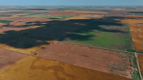 Huge plain territory divided on rectangular areas. Vast dry farmlands from aerial perspective.