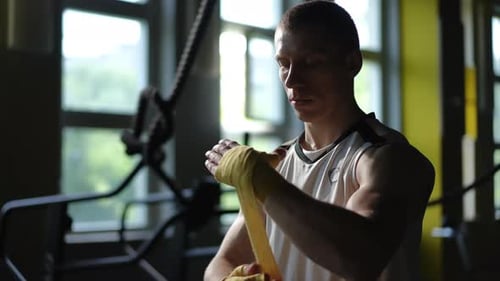 Man Wrapping Hands in Gymnasium Before Boxing Training