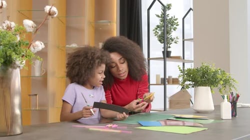 School Age African American Girl and Mother Making Applique From Colored Paper