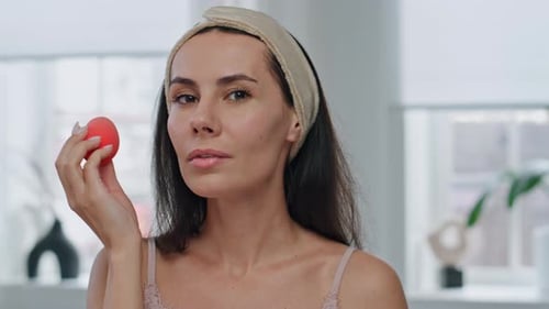 Woman Applies Makeup With Beauty Blender