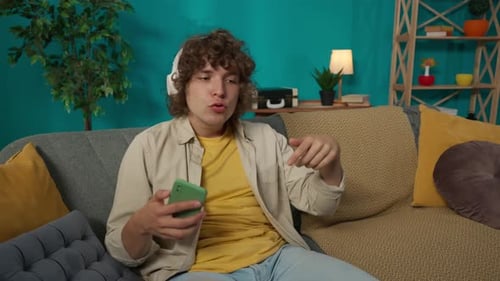 Young Man Listens to Music and Dances at Home