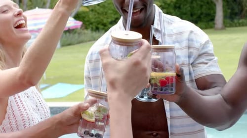 Friends Toasting Fruity Drinks by the Pool