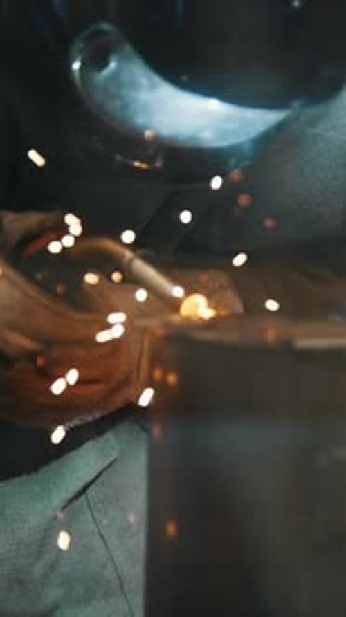 The Welder Welds Metal Parts at the Plant