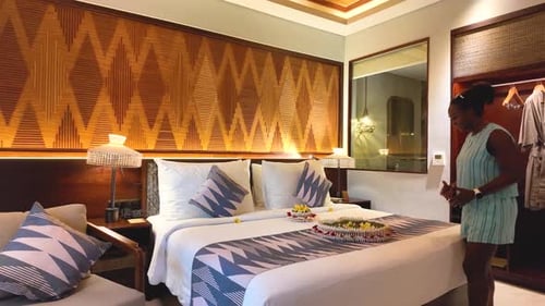 Female Tourist Discovering Romantic Honeymoon Bed and Reacting with Joy in Luxury Hotel Room, Ubud