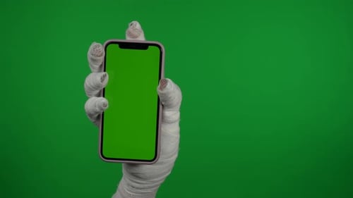 Detail Green Screen Isolated Chroma Key Video Capturing Mummy's Hand Holding a Smartphone with an