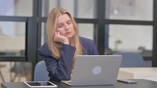 Tired Young Businesswoman Sleeping in front of Laptop