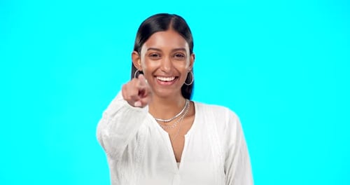 Gesicht, Motivation und indische Frau, die auf dich zeigt, Beförderung und Glück vor einem blauen Studio