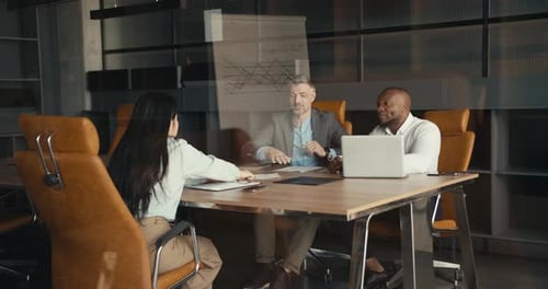 An Overview of Successful Teamwork in the Office A Team of Two Men and a Girl are Discussing a New