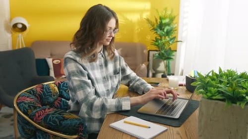 Young Woman Typing on Laptop at Home