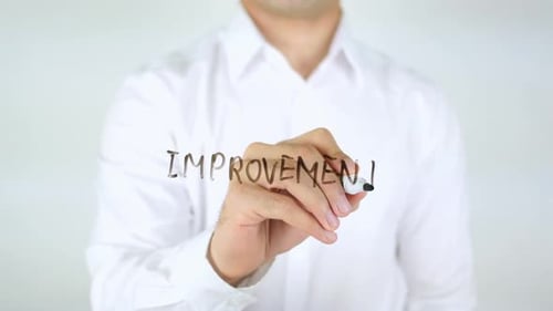 Man Writes the Word Improvement on Screen