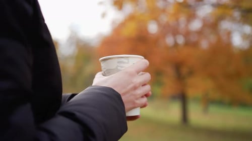 Girl in an Autumn Park with a Glass of Hot Morning Espresso Coffee