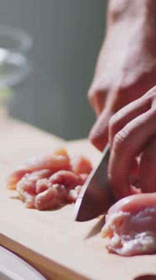 Close-up of Unrecognizable Man Expertly Slicing Chicken Breasts